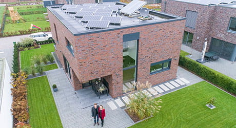 Herr und Frau Thuemler und Ihr EWE Stromspeicher mit einer Solaranlage auf einem Flachdach